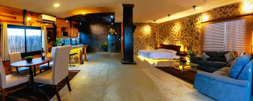 a bedroom with a bed and a living room at Loft Suite Altitude Cabin in Bajos de Chila