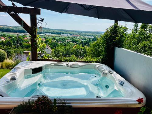 a jacuzzi tub sitting under an umbrella at Panorama Residence Pákozd in Pákozd