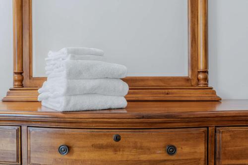 a stack of towels on a dresser in front of a mirror at Steps to Ski Trail Fireplace - Kingswood 1B in Quechee