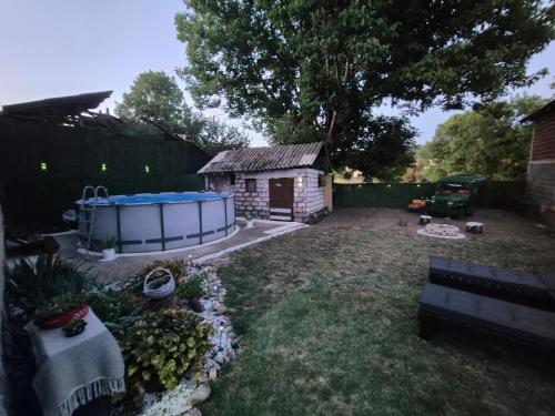 a yard with a small shed and a fence at Apartman Sweet Dreams in Svrljig