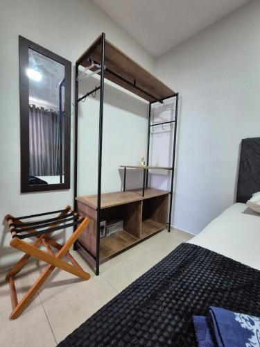 a bedroom with a mirror and a bed and a chair at Apartamento de 1 quarto !! in Joinville