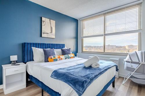 a blue bedroom with a bed and a window at Upscale 2BR Condo with Gym and Free Parking in Arlington