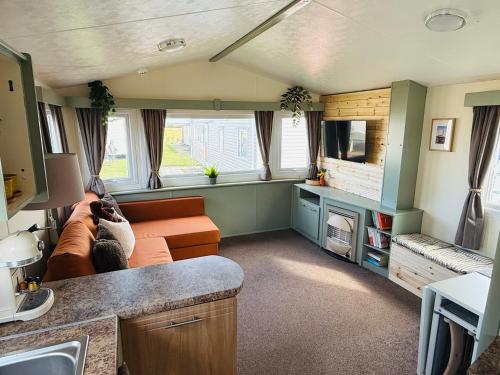 a living room with a couch and a tv at 'Olive' by the Sea in Whitley Bay