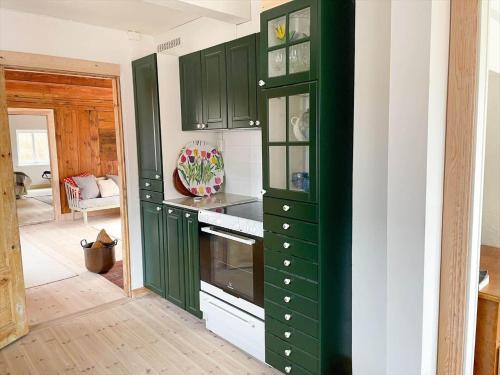 a kitchen with green cabinets and a stove at SKA733-Bastad-Stalhoegavaegen-144 in Grevie