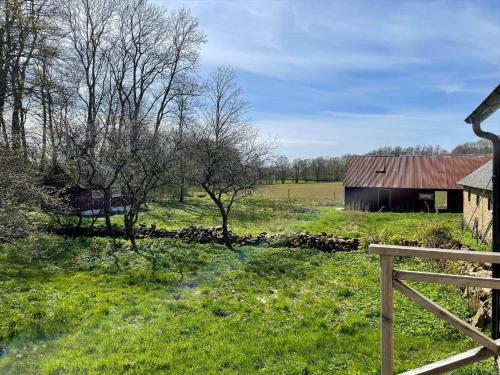 a field with a barn and a fence and trees at SKA733-Bastad-Stalhoegavaegen-144 in Grevie