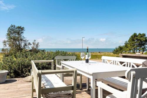 a white table and chairs on a deck with the ocean at SKA418-Nyhamnslaege-Skaelebaeckavaegen-9 in Nyhamnsläge