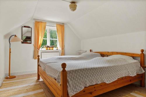 a bedroom with a wooden bed and a window at SKA577-Haestveda-Skaerseroed-2254 in Askustorp