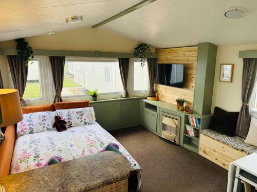 Un dormitorio con una cama, un televisor y un sofá. en 'Olive' by the Sea, en Whitley Bay