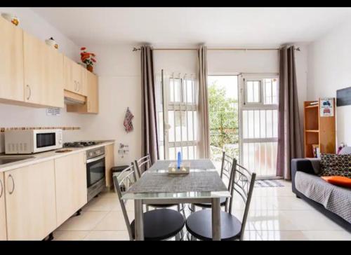 a kitchen with a table and chairs in a room at DELUXE ROOM IN APARTMENT SHARED in Los Cristianos Playa HabitaciónSTANZA air-conditioned in Arona