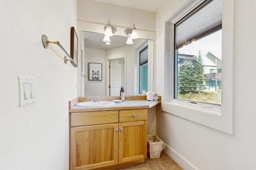 Un baño con lavabo y ventana. en Saddle Ridge G4, en Big Sky
