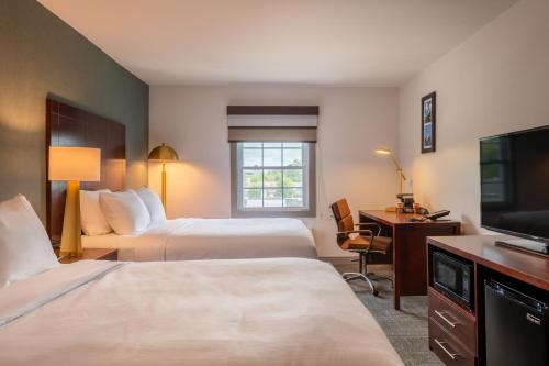 a hotel room with two beds and a desk and a television at Comfort Inn Rockland - Boston in Rockland