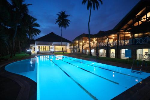 a swimming pool lit up at night at Labadi Beach Hotel in Accra