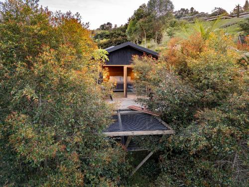 a house with a black roof in the middle of trees at Retreat Villas Llanogrande By CHX in Rionegro