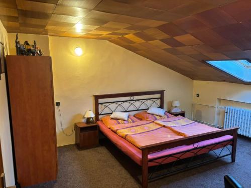 a bedroom with a bed with a wooden ceiling at Tatra Roof Room in Nová Lesná