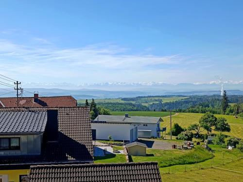 a view of a farm with mountains in the distance at Ferienwohnung in Strittberg mit Sauna und Alpenblick in Höchenschwand