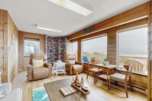 a living room with a table and chairs at A Wave From It All in Rockaway Beach