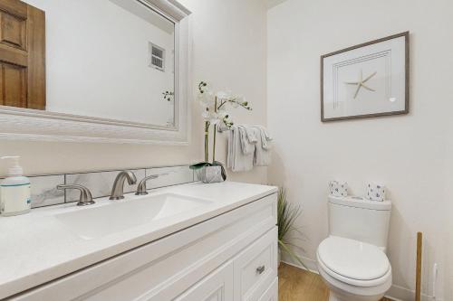 a white bathroom with a sink and a toilet at A Wave From It All in Rockaway Beach