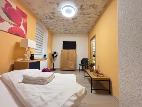 a bedroom with a bed and a table and a tv at Villa Blue Max in Großenhain