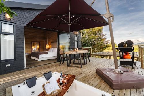 a room with a bed and a large umbrella on a deck at Retreat Villas Llanogrande By CHX in Rionegro