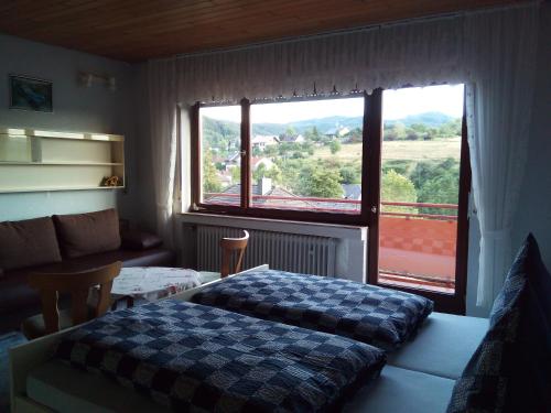 a bedroom with a bed and a large window at Pension Mühlenhardt in Herschbroich