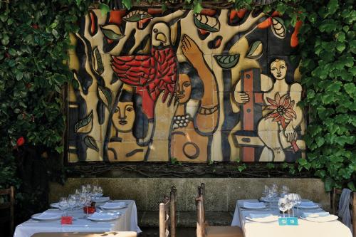 two tables in front of a wall with a painting at Elegant villa - swimming pool - French Riviera in Montauroux