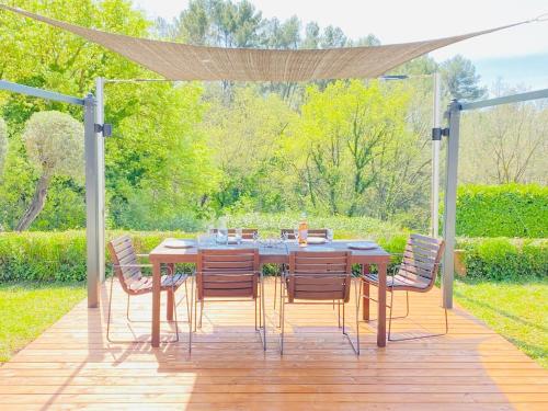 a table and chairs sitting on a wooden deck at Elegant villa - swimming pool - French Riviera in Montauroux