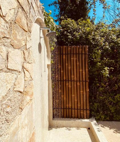 a wooden gate on the side of a stone wall at Elegant villa - swimming pool - French Riviera in Montauroux