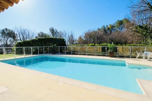 a large blue swimming pool with a fence around it at Elegant villa - swimming pool - French Riviera in Montauroux
