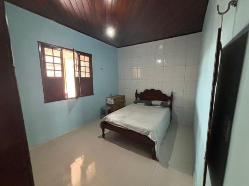 a bedroom with a bed in a room with a window at Casa para COP30 in Belém
