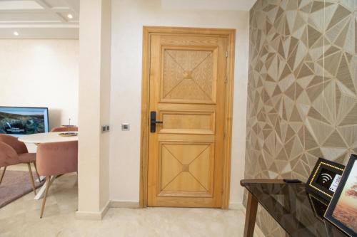 a wooden door in a room with a table at Luxe & sérénité près de l Aireport Mohamed 5, votre Havre de Paix in Nouaseur