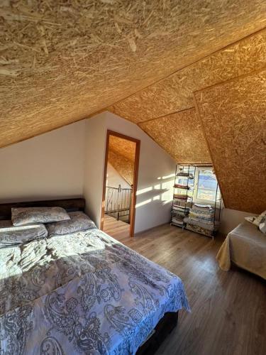 a bedroom with a bed and a wooden ceiling at The Familay Garden in Nurrnus