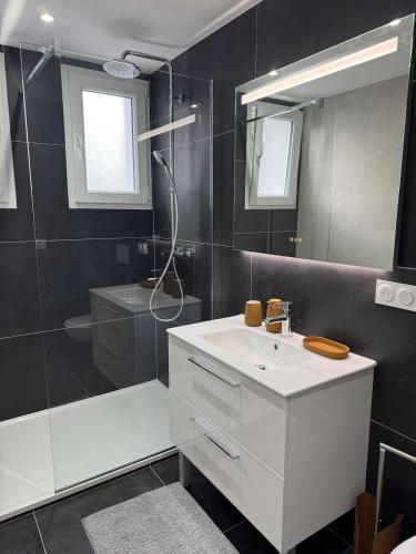 Un baño con lavabo blanco y ducha en Longchamps 2 - Grand appartement 73m2 neuf spacieux, en Aix-les-Bains