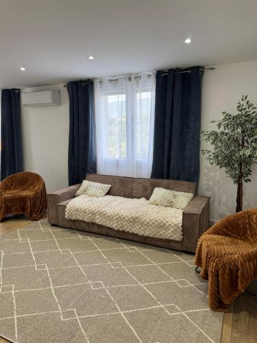 Una sala de estar con un sofá y una ventana. en Longchamps 2 - Grand appartement 73m2 neuf spacieux, en Aix-les-Bains