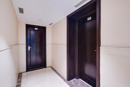 two black doors in a room with white walls at Palette Sapphire Star Chappan Market in Indore