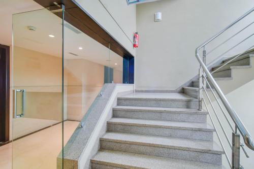 a staircase in a house with glass railing at Palette Sapphire Star Chappan Market in Indore