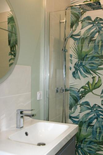 a bathroom with a sink and a shower at Le Colombier - Chambre Mésange in Baule