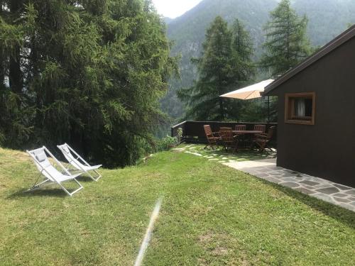 a group of white chairs sitting on a lawn at Chalet Alma in Champoluc