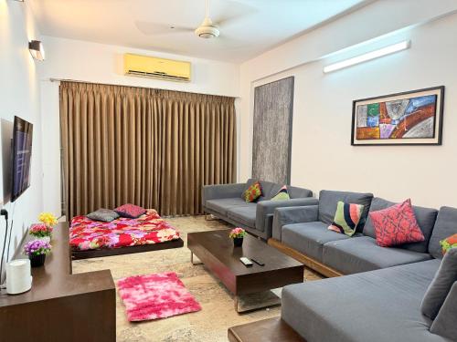 a living room with two couches and a table at Premium 3 BR Apartment in Uttara Near Airport and Metro Sector 7 AC Wifi Modern Comfort in Bāiljuri