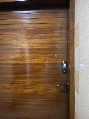 a wooden door with a person walking through it at Premium 3 BR Apartment in Uttara Near Airport and Metro Sector 7 AC Wifi Modern Comfort in Bāiljuri
