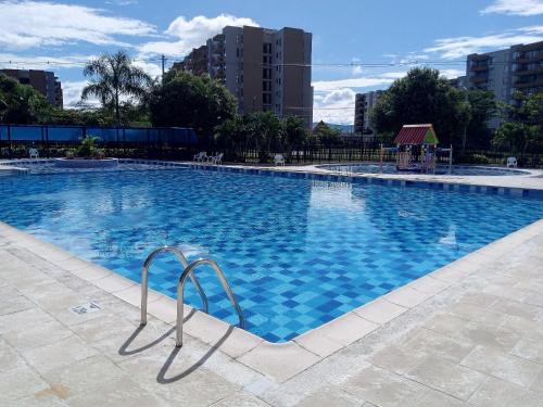 a large swimming pool with blue water in a city at AH/ Relax con vista natural, Peñalisa Ricaurte in Ricaurte
