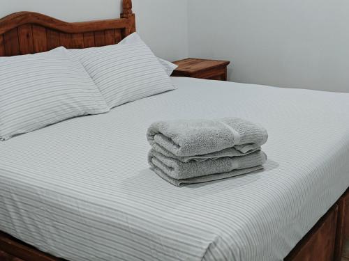 a pile of towels sitting on top of a bed at Cerca de Salones de Fiesta, con Alberca, AC e Internet in Xochitepec
