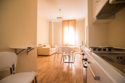 - une cuisine avec une table et des chaises dans la chambre dans l'établissement Dante Ravenna Apartments, à Ravenne