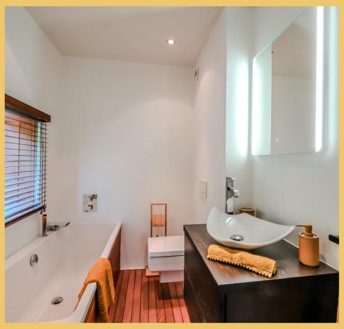 un bagno con vasca, lavandino e vasca da bagno di Villa vue Lac Léman et montagne Proche Genève a Cranves-Sales