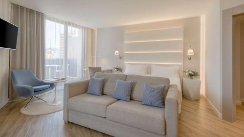 a living room with a couch and a bed at NH Málaga in Málaga