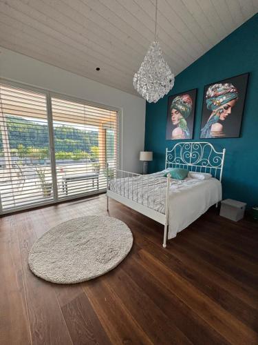 a bedroom with blue walls and a bed with a rug at Boutique Penthouse Terrace Apartment in JuraParc in Wil
