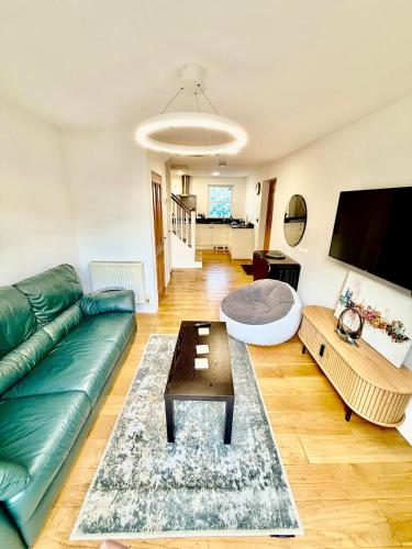 a living room with a green couch and a table at Beautiful Modern 2 Bed house combined with a vintage feel near Central Cambridge Sleeps 4 in Cambridge