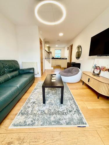 a living room with a green couch and a table at Beautiful Modern 2 Bed house combined with a vintage feel near Central Cambridge Sleeps 4 in Cambridge