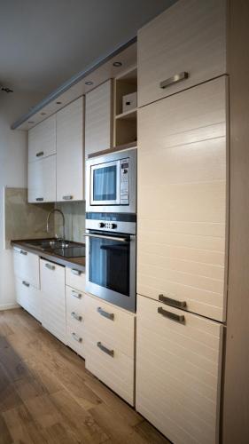 a kitchen with white cabinets and a microwave at Conte Durini Apartments & Rooms in Arcore