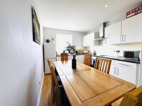 a kitchen with a wooden table with a vase of flowers on it at Skyline View Apartment in Edinburgh
