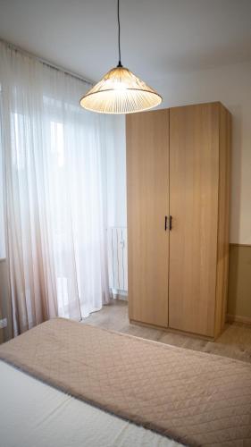 a room with a bed and a cabinet and a light at Conte Durini Apartments & Rooms in Arcore